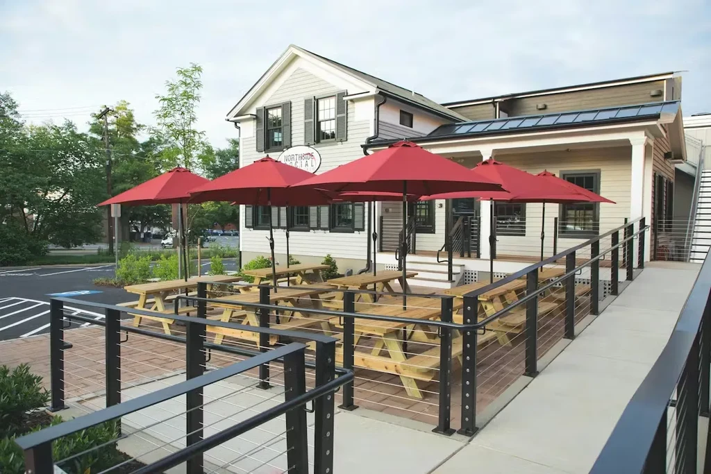 Exterior of Northside Social restaurant with patio, red umbrellas, and ramp.