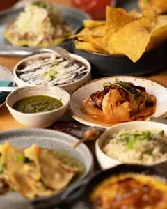 Vibrant close-up of diverse Mexican dishes with prominent tortilla chips.