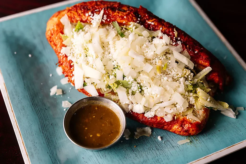 Red chile huarache topped with onion, queso fresco and lettuce