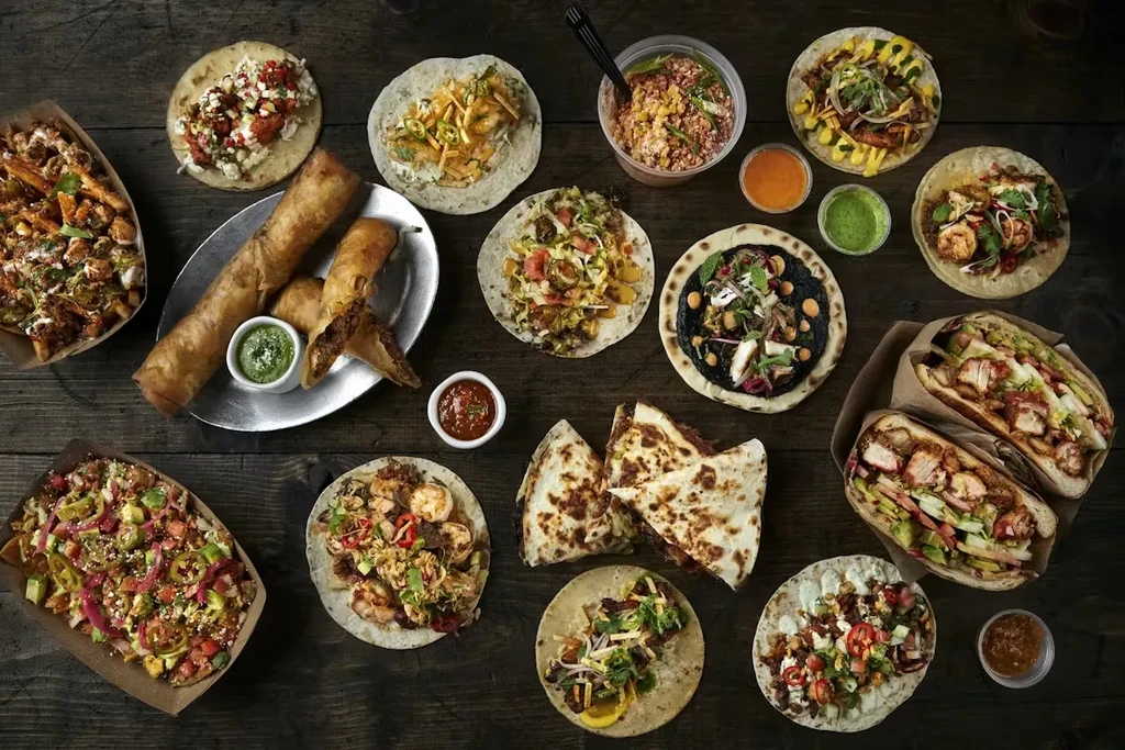 Overhead: Large spread of Mexican food on a rustic wooden table.