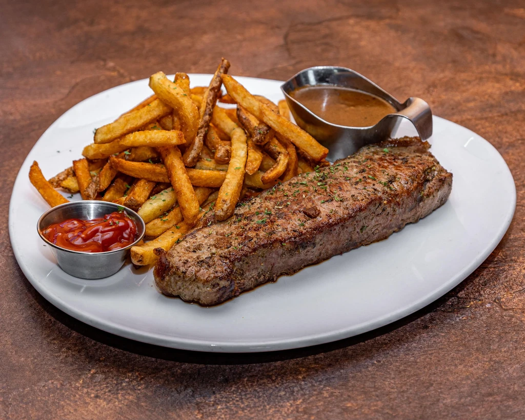 Grilled steak frites with ketchup and brown sauce.