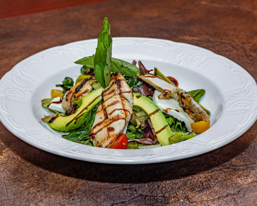 Grilled chicken salad with avocado, mozzarella, tomatoes, and balsamic glaze.