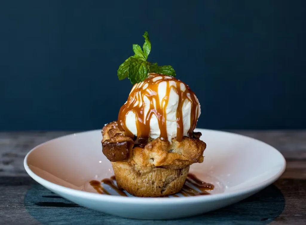 Baked dessert with vanilla ice cream, caramel sauce, and a mint sprig.