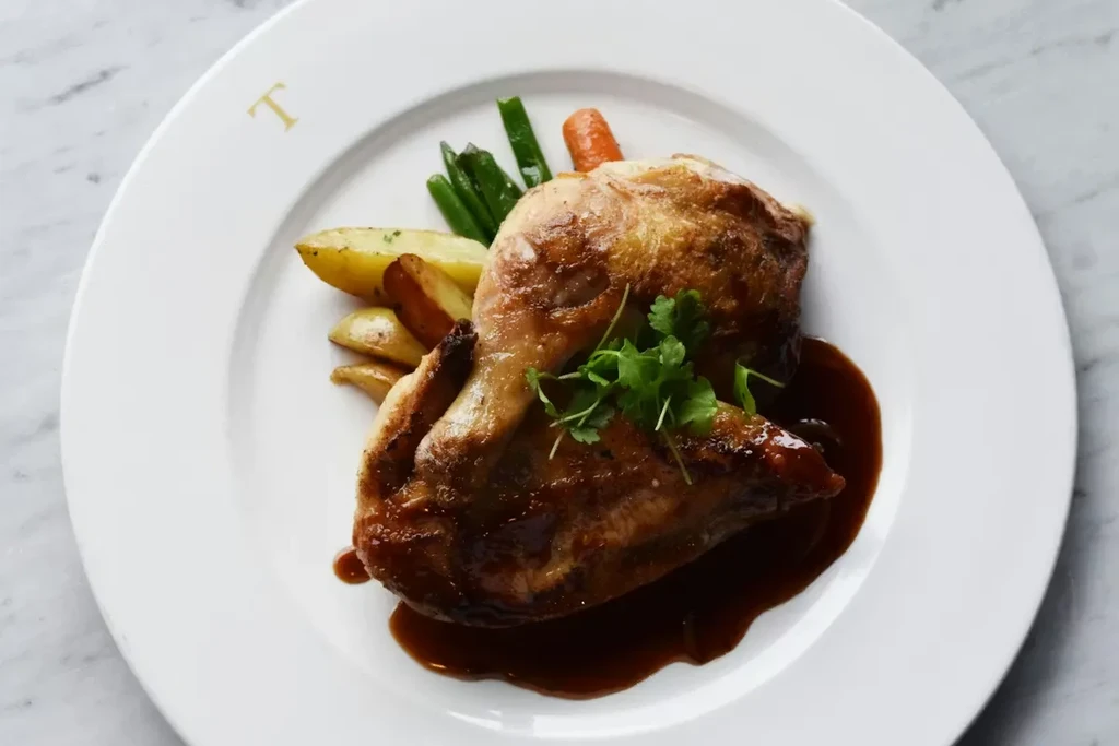 Roasted chicken with gravy, potatoes, green beans, and carrots.