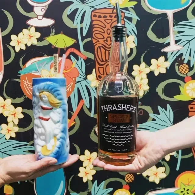 Tropical bar scene with a tiki mug and Thrasher's Spiced Rum.