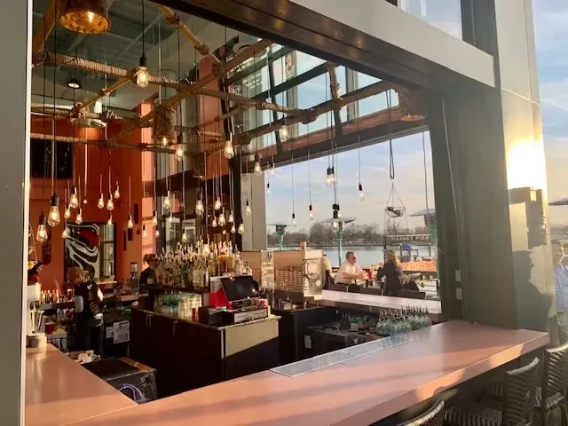 Restaurant bar with Edison bulbs and Market Pier waterfront view.