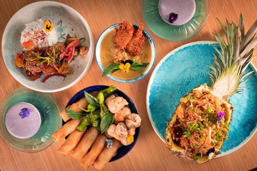Overhead view of a colorful spread of diverse dishes and drinks.
