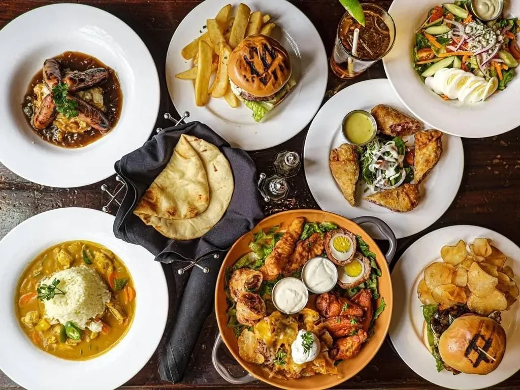 Diverse food spread, appetizers, and a drink, seen from above.