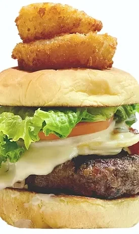 Stacked burger: beef, melted cheese, lettuce, tomato, fried egg, onion rings.