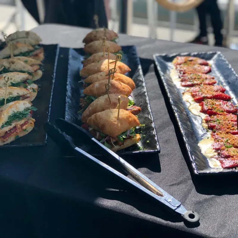 Three appetizer platters with sandwiches and cured meat.