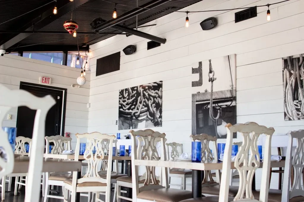 Modern industrial dining room with white shiplap and Edison string lights.