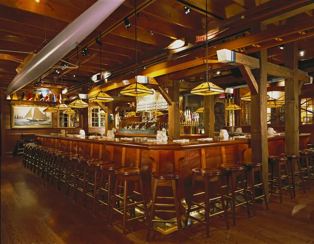 Rustic wooden bar with a suspended rowing shell and nautical decor.
