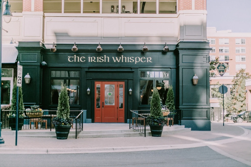 The Irish Whisper restaurant exterior, green facade with red double doors.