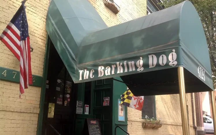 The Barking Dog restaurant exterior with green awning, American and Maryland flags.