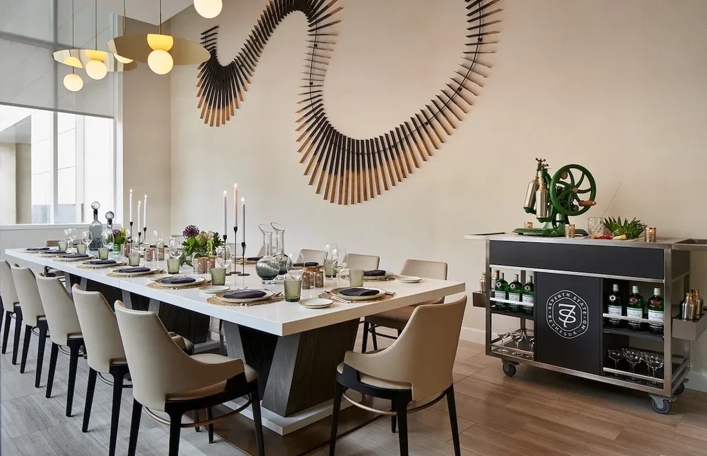 Modern private dining room, set table, branded bar cart, wooden wall art.