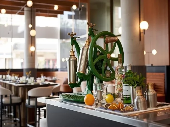 Modern bar counter, vintage green machine, liquor, and fruit.