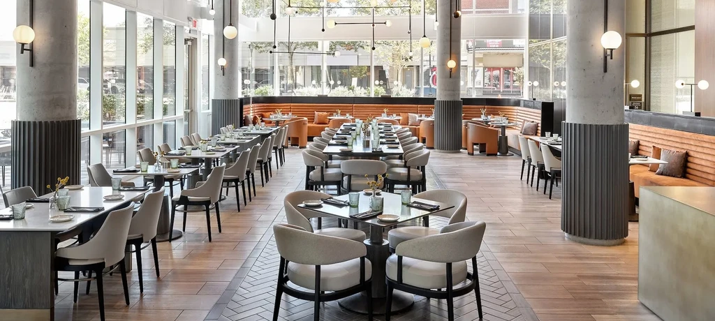 Modern, empty restaurant interior with natural light and varied seating.