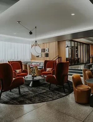 Modern lounge with burnt orange velvet armchairs and coffee table.