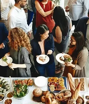 High-angle view: People select varied food from a vibrant buffet.