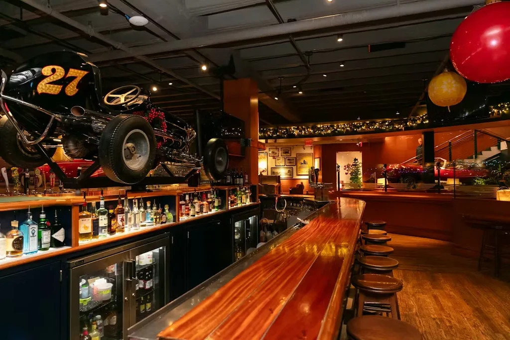 Themed bar with a suspended vintage black race car and holiday decorations.
