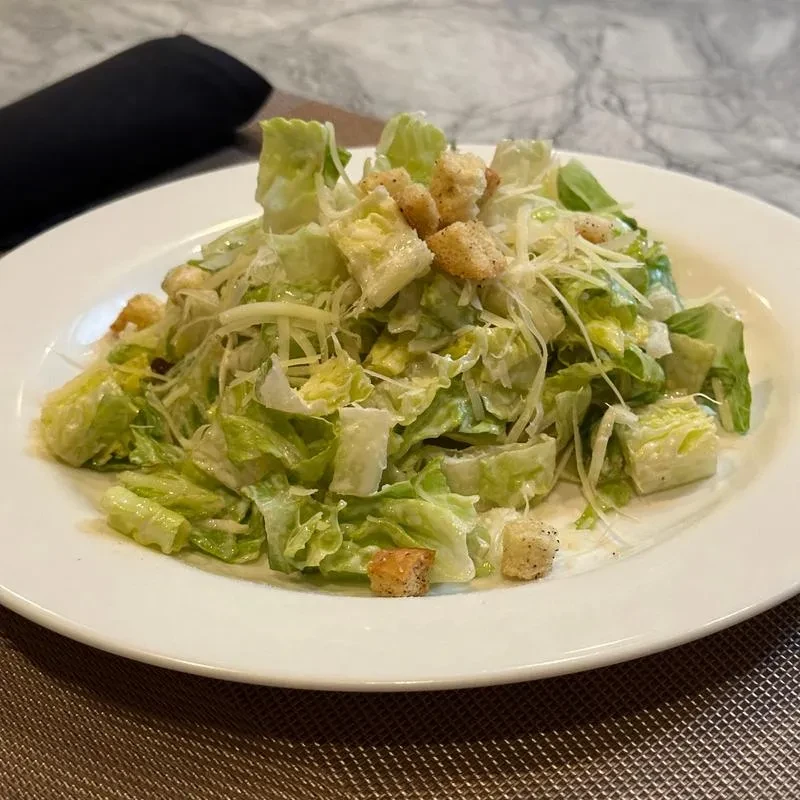 Caesar salad with romaine lettuce, dressing, croutons, and shredded Parmesan.