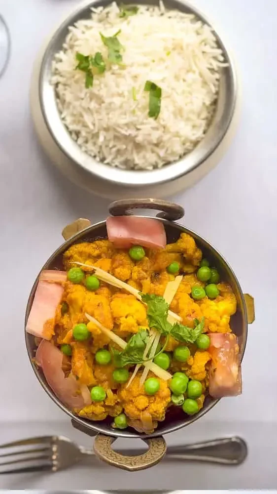 Overhead: Indian Gobi Matar curry and cilantro-garnished basmati rice.