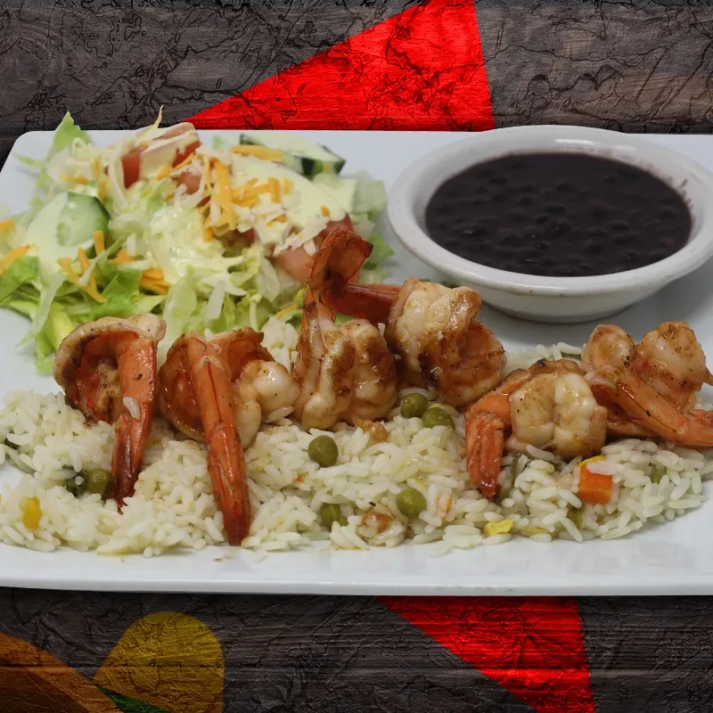 Grilled shrimp, rice with vegetables, side salad, and black beans.