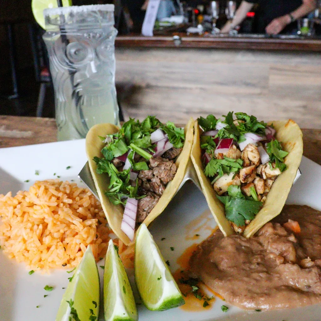 Mexican tacos, rice, beans, and a green tiki cocktail.