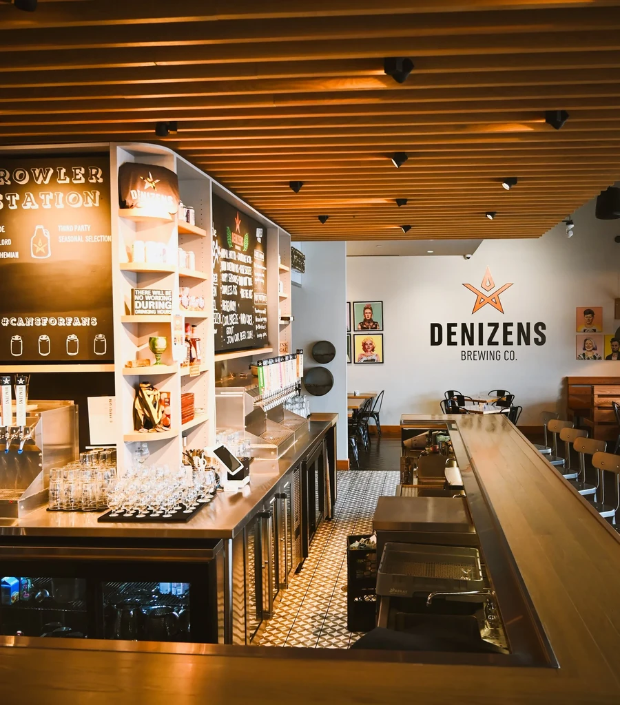 Modern Denizens Brewing Co. taproom with beer taps and growler station.