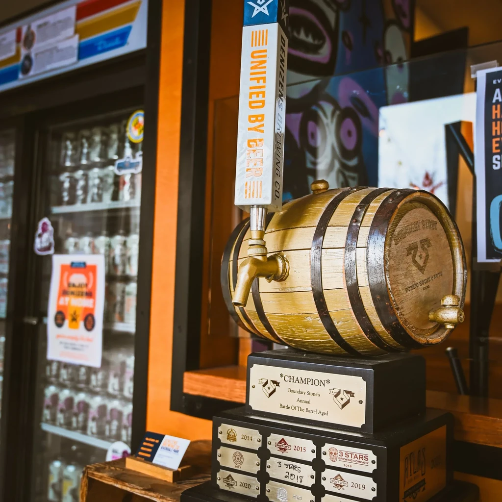 Champion Denizen's Brewing Co. tap handle and barrel on a trophy stand.
