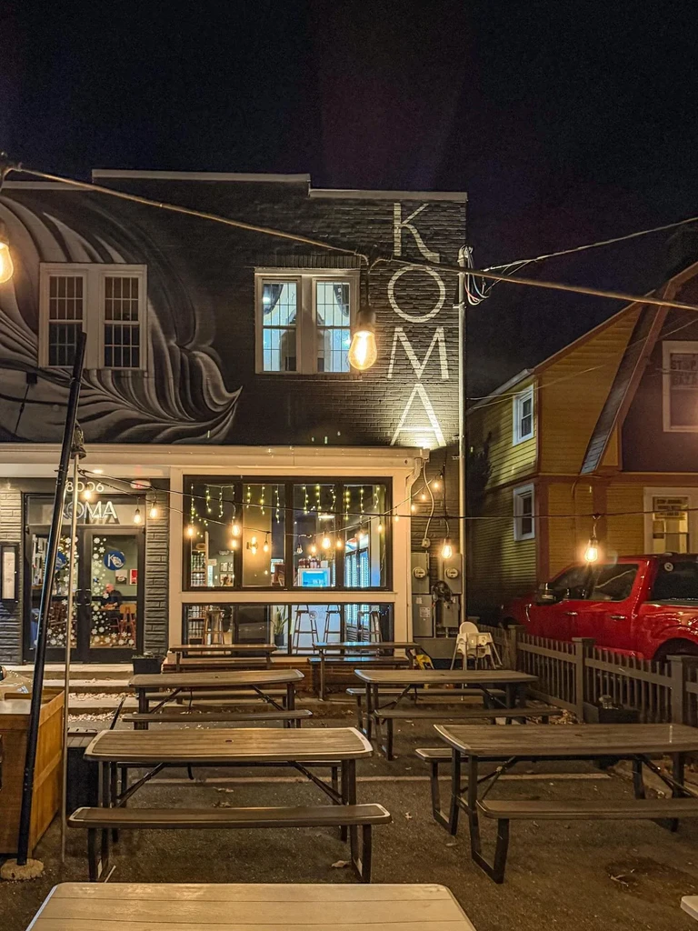 KOMA restaurant exterior at night with string-lit patio tables.