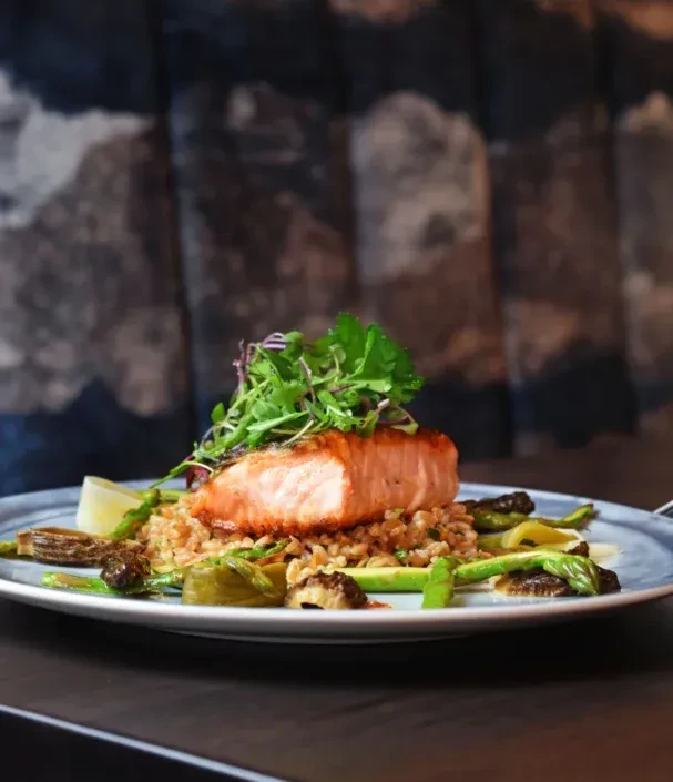 Crisp-skinned salmon on grain pilaf with green vegetables and lemon.
