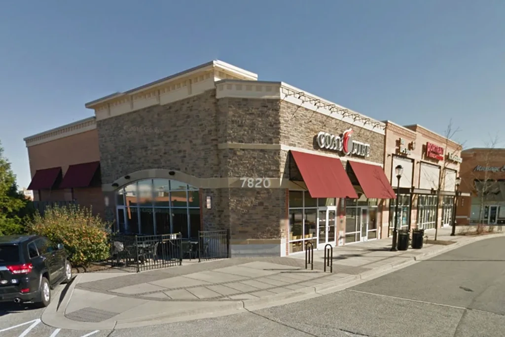 Coal Fire restaurant's stone facade and red awnings on a clear day.