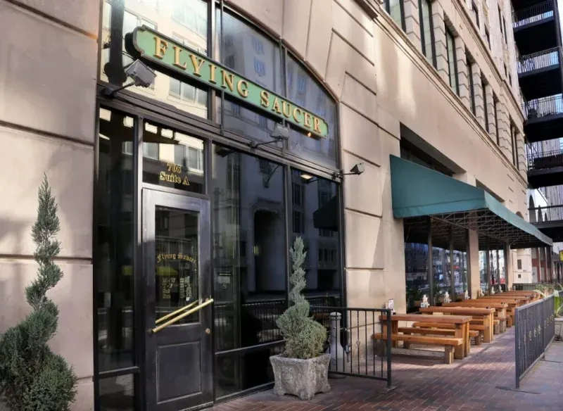 Flying Saucer restaurant's stone facade and outdoor patio seating.