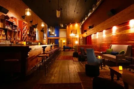 Interior view of a dimly lit bar with a long wooden counter.