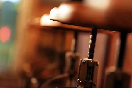 Close-up of a stool's metal height adjustment screw and bracket.