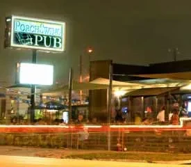 Exterior of Porch × Wing Pub at night with outdoor seating.