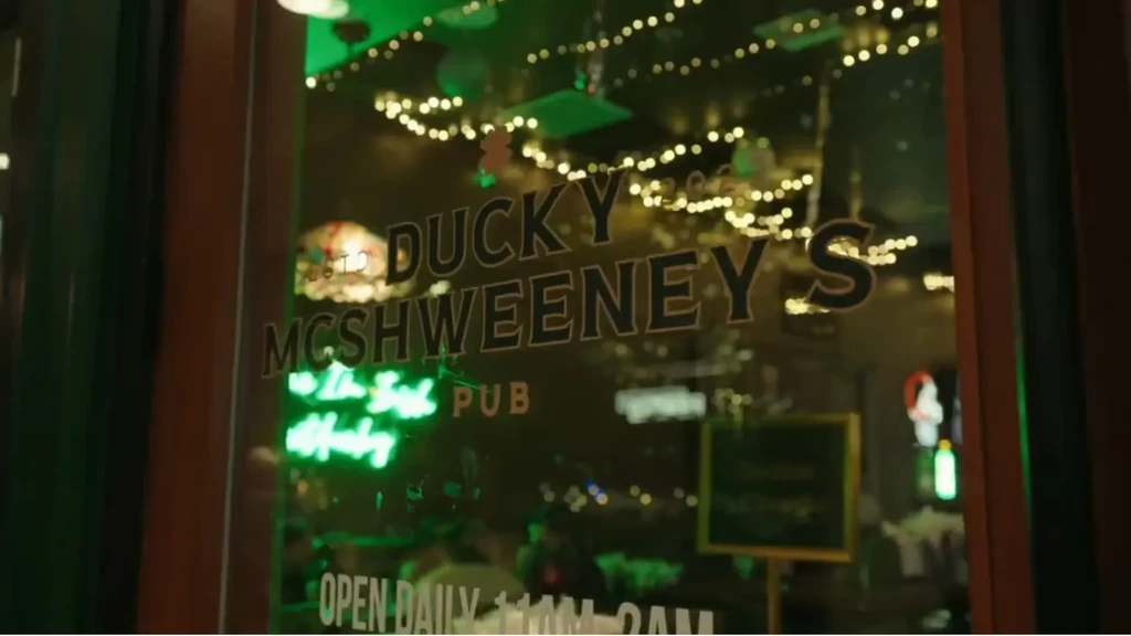 Exterior of Ducky McSweeney's Pub with a green neon sign.