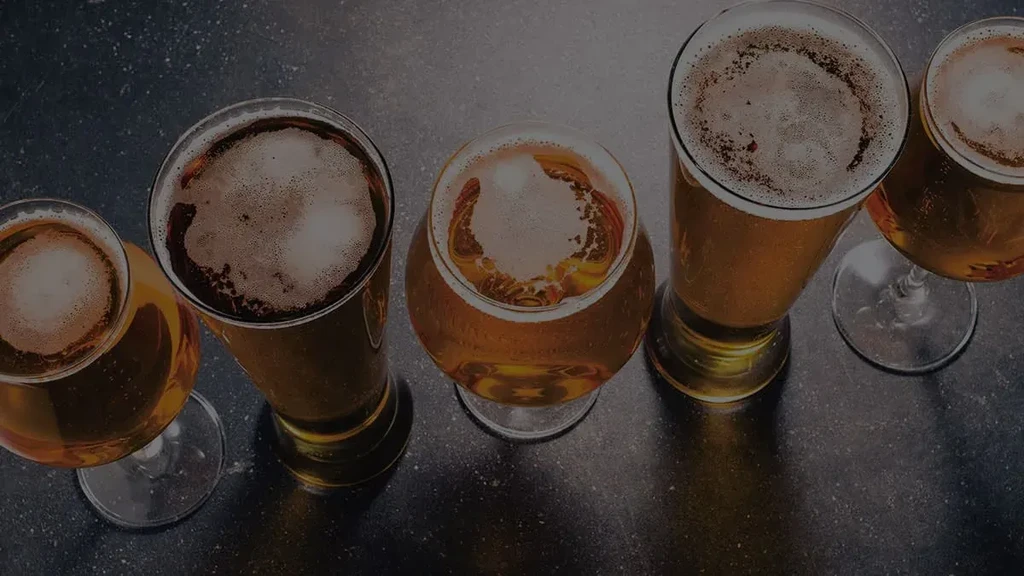 Overhead view of five glasses of beer with frothy heads.