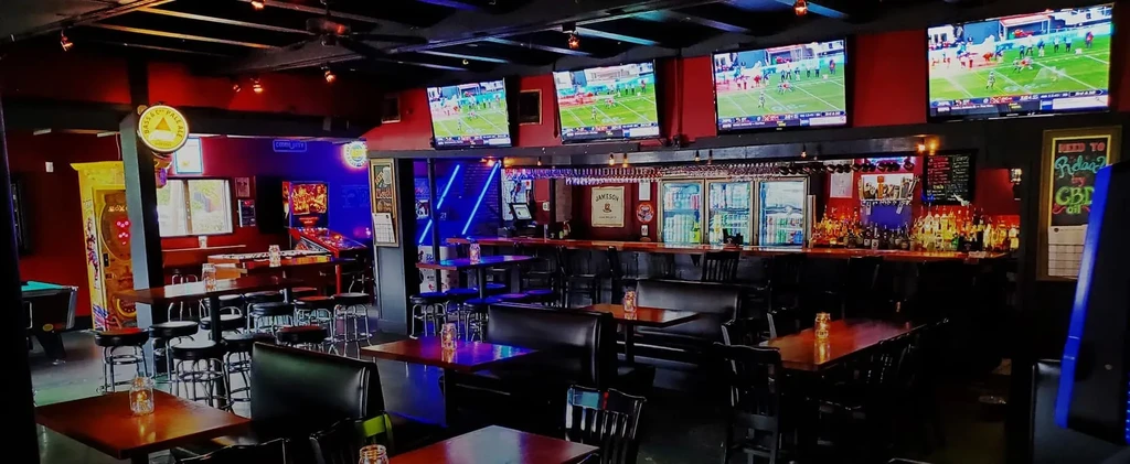 Interior of a dimly lit bar with a fully stocked bar.