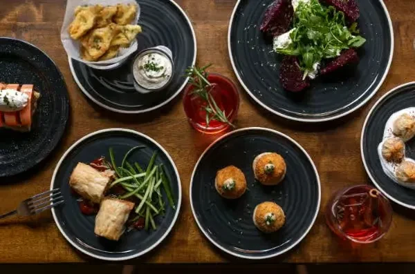 Overhead view of a table with plates of food and drinks.