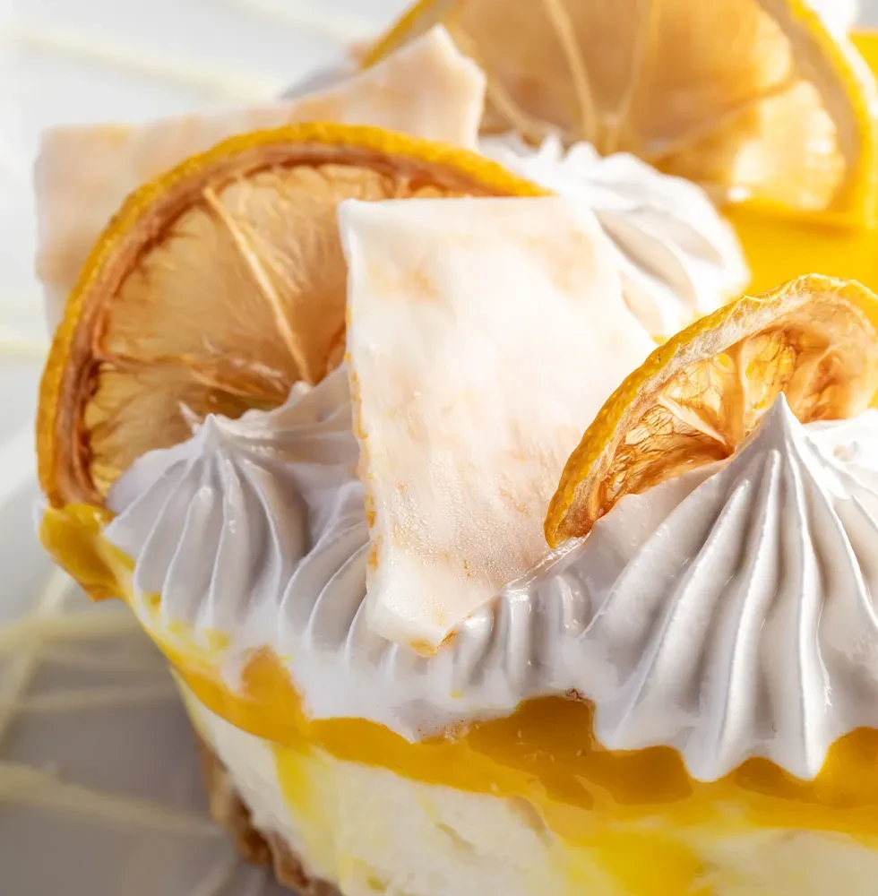 Lemon meringue dessert with dried lemon slices and white chocolate.