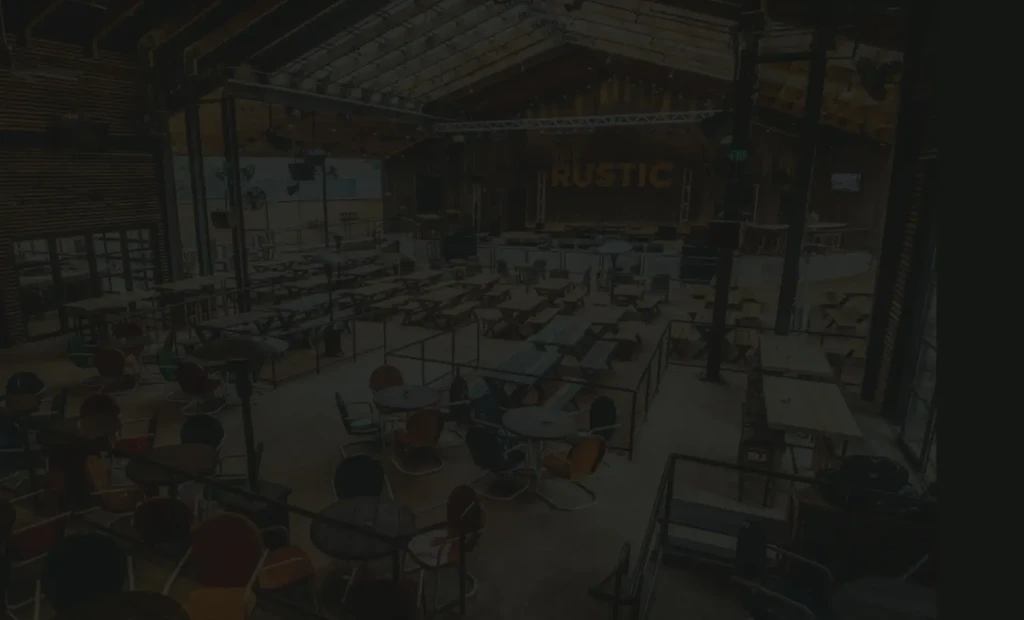 Empty restaurant or bar with "RUSTIC" on stage.