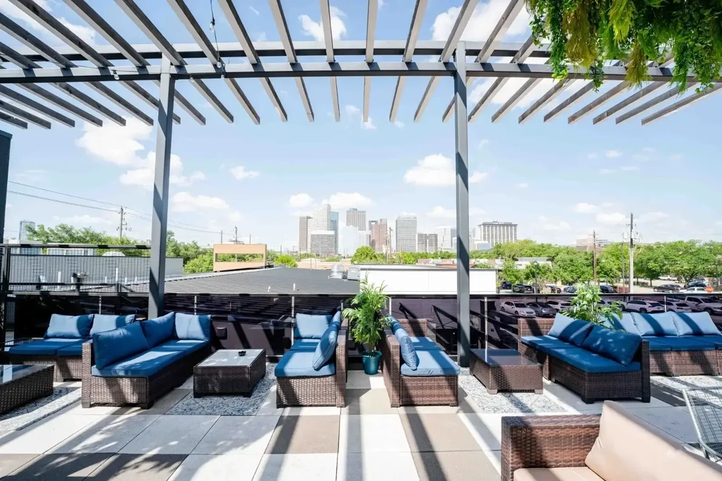 Rooftop patio with lounge furniture under a modern pergola.