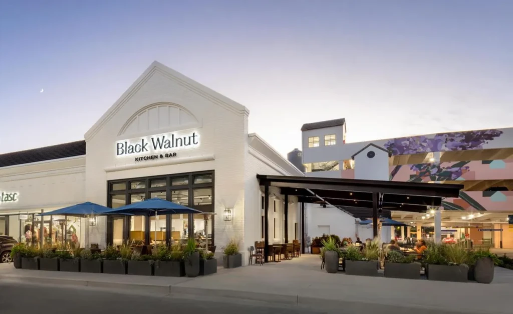 Exterior of Black Walnut Kitchen & Bar with patio and mural.