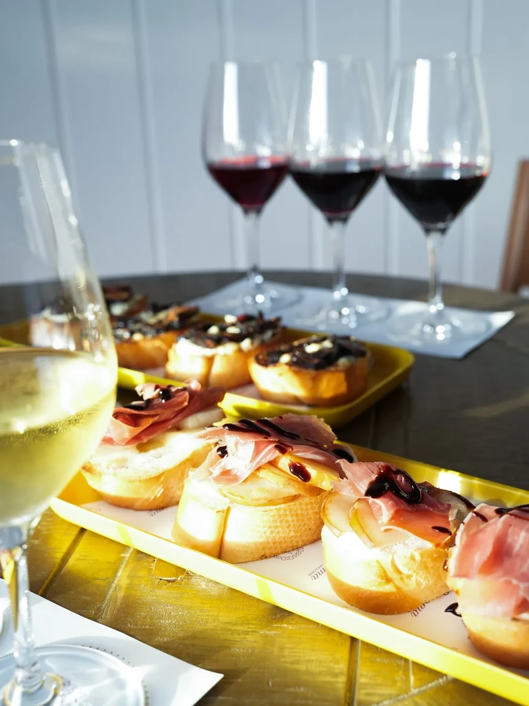 Bruschetta and wine glasses on a rustic wooden table.
