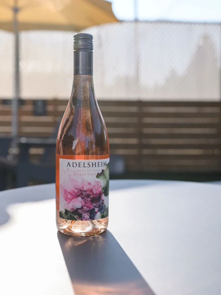 Adelshiem Willamette Valley Rosé of Pinot Noir bottle on outdoor table.