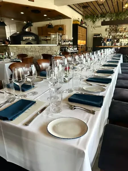 Dining table set in a restaurant with a pizza oven.