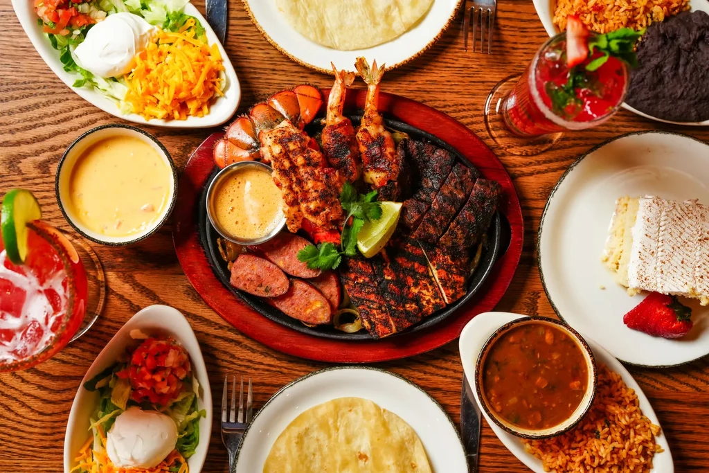 Top-down view of a wooden table laden with various dishes.