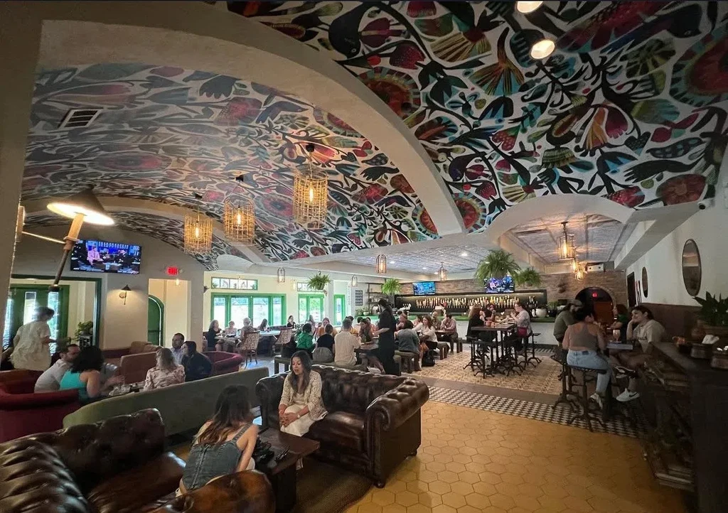 Restaurant interior with a colorful, arched, floral-patterned ceiling.